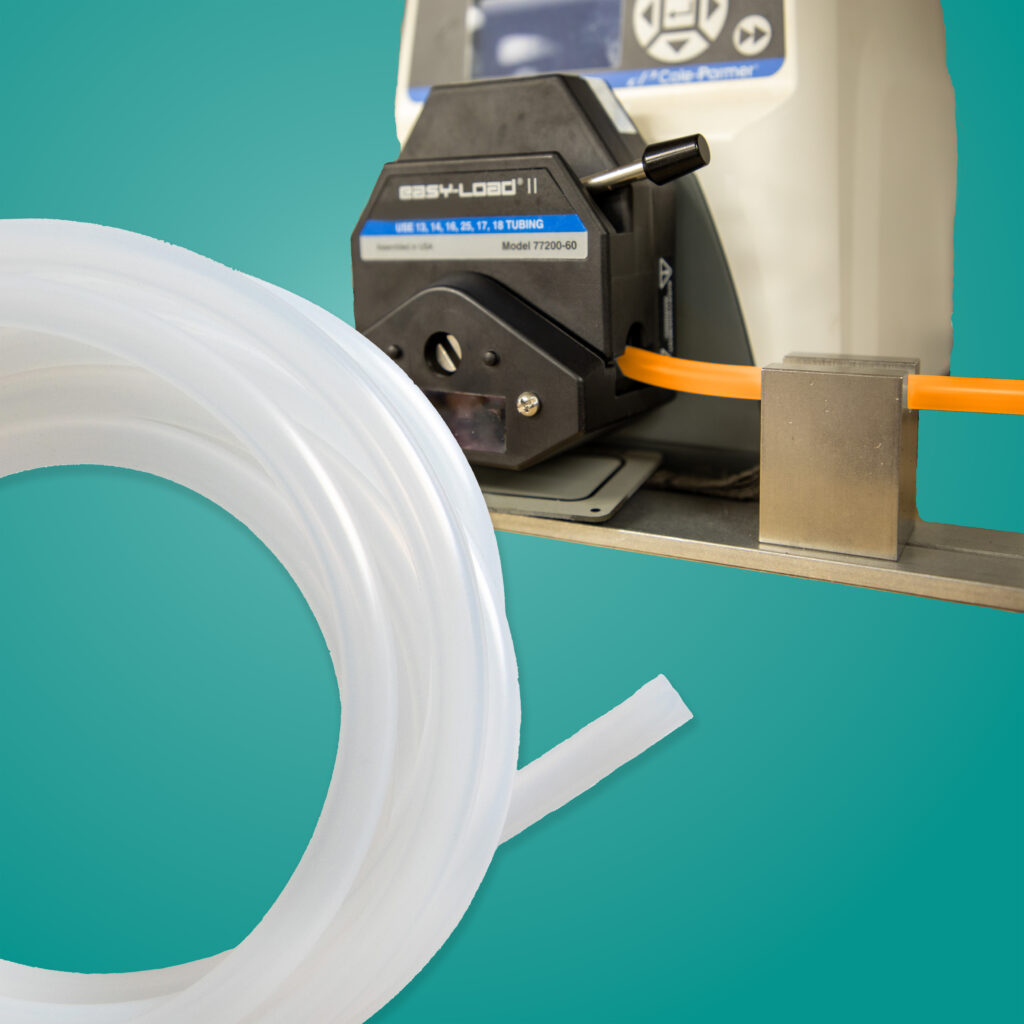 Image of a coil of APSPG Pump tubing in the lower left foreground and a pump with tubing with orange liquid flowing through in behind in the upper right corner on a teal background