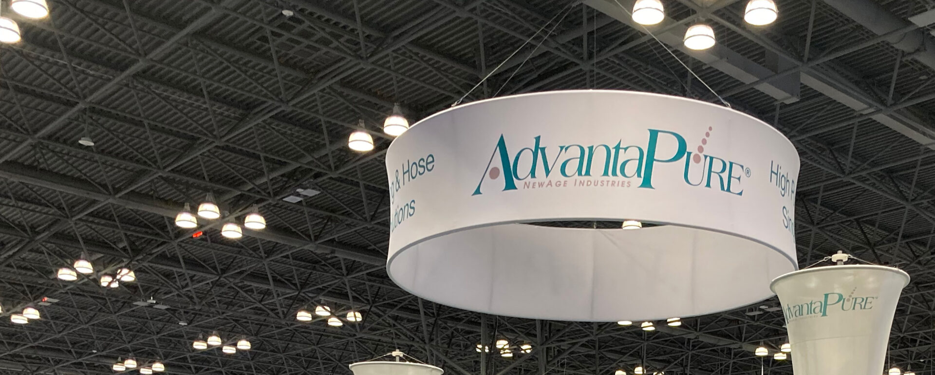 Photo of hanging rotating AdvantaPure circular tradeshow sign